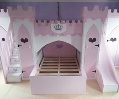 a pink princess castle bed with stairs to the top