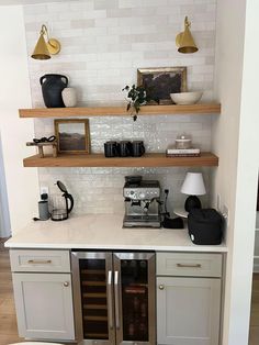 a kitchen with open shelving and wine coolers on the counter top in front of it