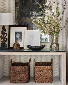 a shelf with baskets and flowers on it