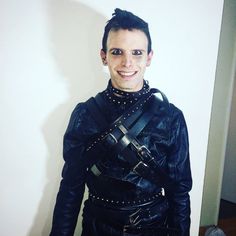 a man dressed in black leather poses for the camera