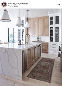 a large kitchen with marble counter tops and wooden cabinets, along with an area rug on the floor