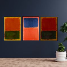 three paintings are hanging on the wall next to a potted plant in a room