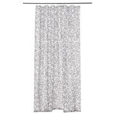 a white and grey shower curtain hanging on a rod