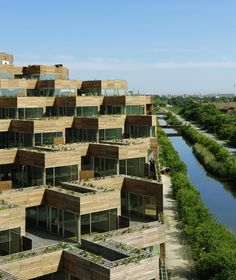 an apartment building with lots of windows and plants growing on the side of it's sides