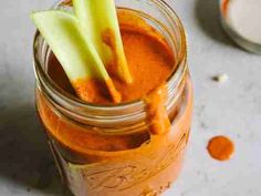 a glass jar filled with carrots and some sort of pickle on top of it