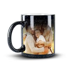 a black and white coffee mug with the image of two people holding a baby in their arms