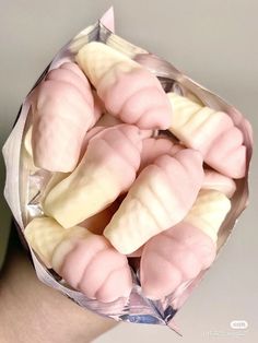 a person holding a bag full of pink and white candy