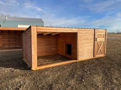 a small wooden shed sitting on top of a dirt field