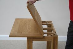 a person standing next to a table that is made out of two pieces of wood