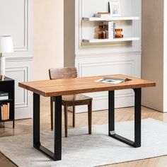 a wooden table sitting on top of a hard wood floor next to a book shelf