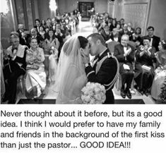 a couple kissing each other in front of a large group of people on their wedding day