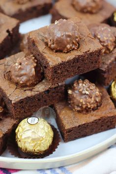 chocolate brownies on a white plate with gold foiled hersheys in the middle