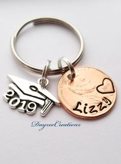 two different key chains with one penny and the other has a hand holding a heart