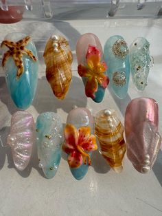 About this item: Dive into the Tropics: Our medium almond press-on nails are your ticket to a tropical paradise! Adorned with ocean-inspired elements like starfish, seashells, and vibrant tropical flowers, these nails are perfect for capturing that summer vibe all year round. Easy, Breezy, Beachy: These nails are not only reusable and lightweight, but they're also super easy to apply, giving you a salon-quality manicure in minutes. Whether you're dreaming of the beach or just want to add a splas Tropical Flower Design Nails, Nail Art Designs Tropical, Ocean Inspo Nails, Ocean Inspired Nail Art, Pastel Beach Nails, Summer Nails Charms, Cute Nails Beach, Ocean Waves Nails, Hawai’i Nails