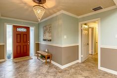 an empty room with a red door and light fixture