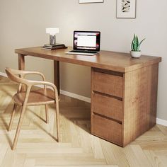 a wooden desk with a laptop on top of it next to a chair and potted plant