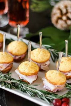 small appetizers are arranged on a platter with rosemary sprigs and pine needles