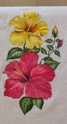 a white towel with yellow and red flowers painted on it's side, sitting on a table