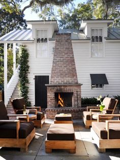 an outdoor living area with chairs and a fire place