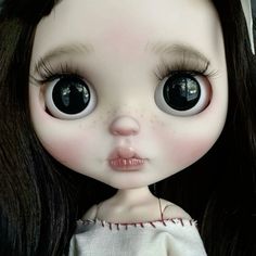 a close up of a doll with big eyes