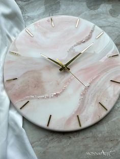 a marble clock with gold hands on a table