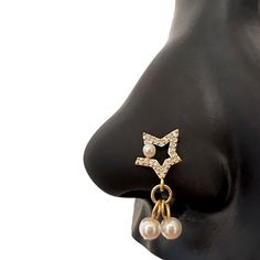 a pair of earrings with pearls hanging from it's earpieces on a mannequin head