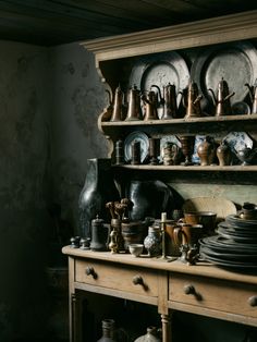 an old wooden table topped with lots of dishes