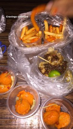 several plastic containers filled with food on top of a wooden table