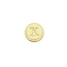 a small gold button with the letter x on it's center and two crossed legs