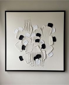 a white and black artwork hanging on the wall