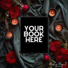 a black square sign surrounded by red flowers and candles with the words your book here on it