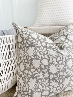 two gray and white pillows sitting on top of a couch