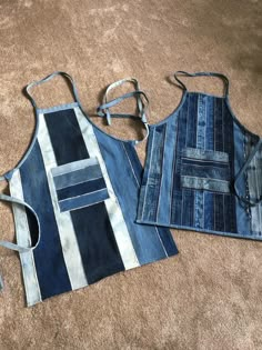 two denim aprons laying on the floor next to each other