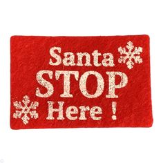 a red door mat with white snowflakes on it that says santa stop here