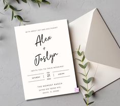 an envelope and wedding card on top of a table next to some greenery, with the word alex + totally written in black ink