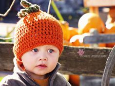 a young boy wearing an orange knitted hat