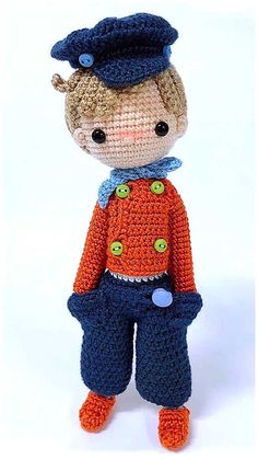 a crocheted doll is wearing an orange shirt and blue pants