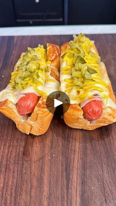 two hot dogs with mustard and ketchup on a wooden table