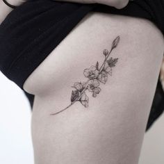 a woman's thigh with a flower tattoo on it