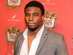 a man standing in front of a red carpet with the words great comet on it