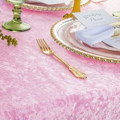 the table is set with pink and gold place settings