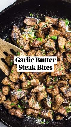 steak and broccoli stir frying in a skillet with wooden spoons