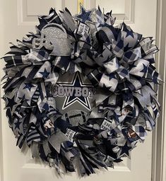 a football wreath is hanging on a door with the word cowboys painted on it,