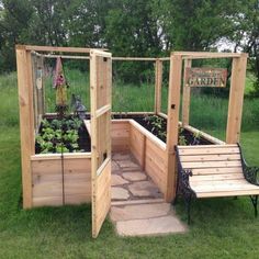 an outdoor garden with wooden planters, benches and plants in the middle of it