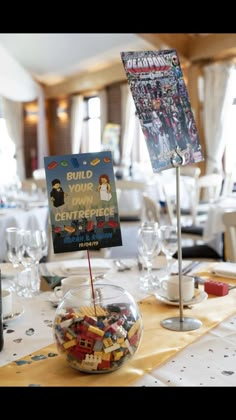 there is a bowl full of legos on top of the table with a sign that says your own centerpiece