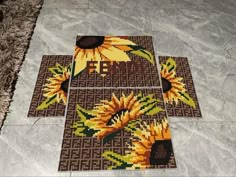 four sunflowers are arranged on the floor in this mosaic art work that is done with cross - stitch