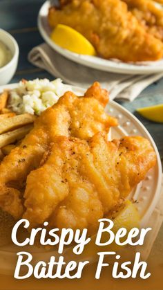 crispy beer battered fish served on a plate with lemon wedges and potato wedges