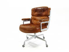 a brown leather office chair with chrome frame and footrests on an isolated white background