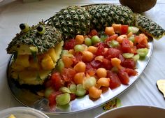 pineapples, melons and other fruits are arranged on a platter for consumption