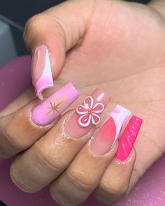 a woman's hand with pink and white nail polish on her nails, holding a pink and white manicure